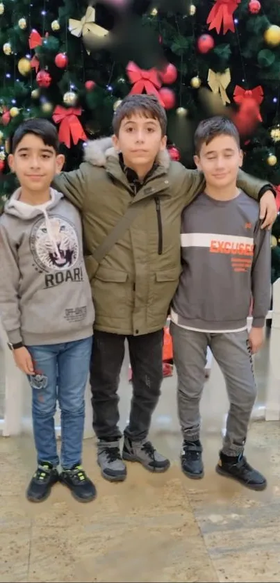 Three kids posing in front of a decorated Christmas tree.