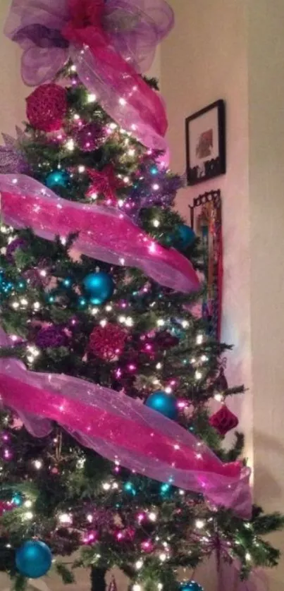 Vibrant Christmas tree with pink ribbons and teal ornaments.