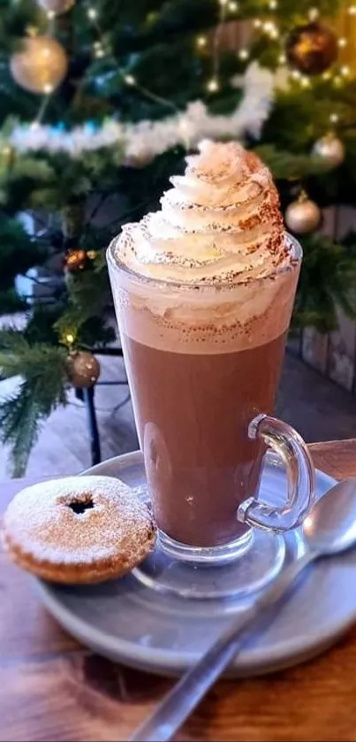 A festive coffee with cream beside a decorated Christmas tree.