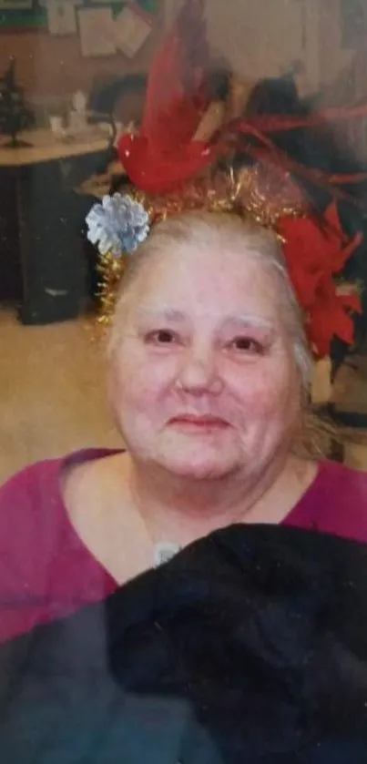 Elderly woman with festive red decorations in a vibrant portrait.