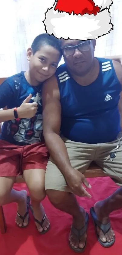 Father and son seated with Santa hat during holidays.