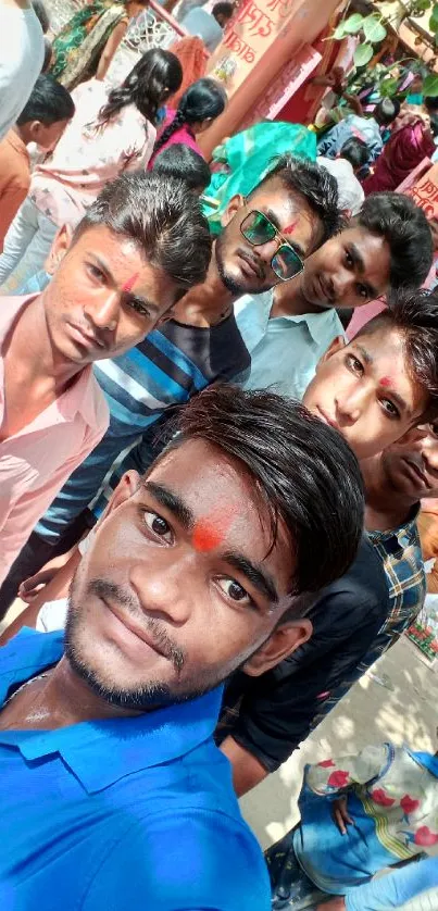 Group of young friends celebrating with colorful festival decor.