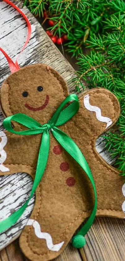 Gingerbread man with green ribbon on rustic wood and pine, festive wallpaper.