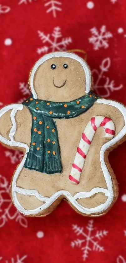 Festive gingerbread man with candy cane on red snowflake background.