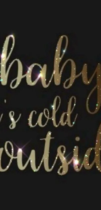 Gold script on black background reading 'baby it's cold outside,' with festive touch.