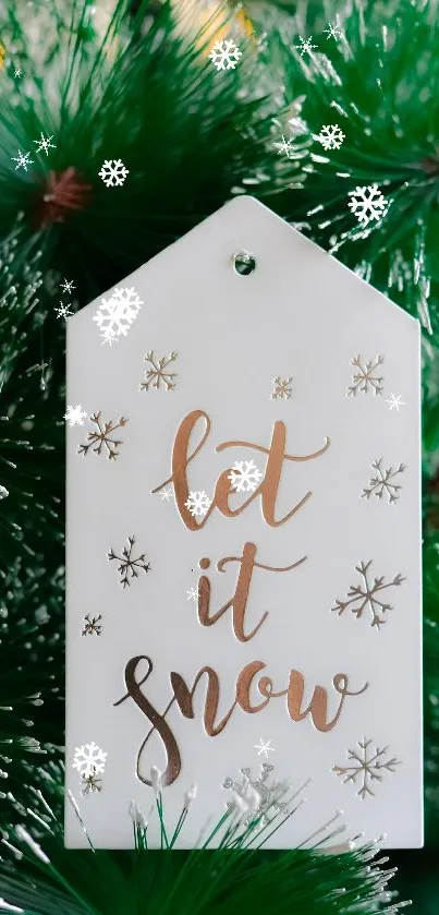 Festive 'Let it Snow' tag on green pine needles.