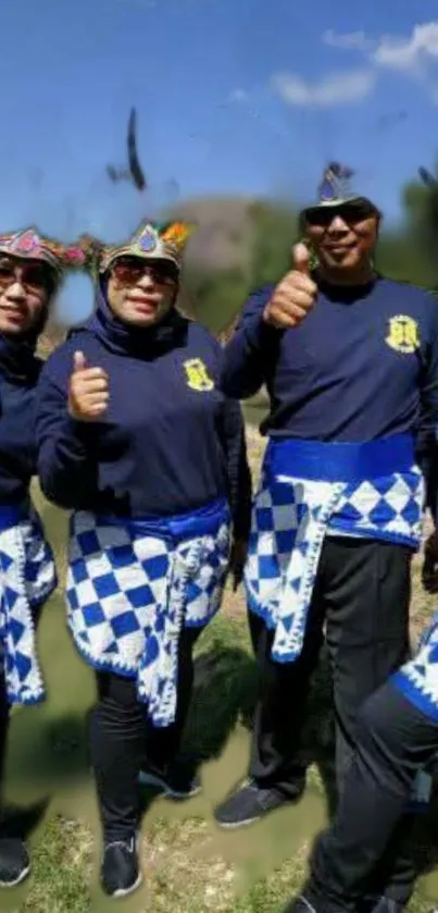 Group of four in vibrant blue traditional outfits outdoors.