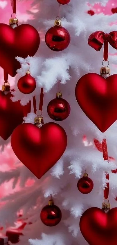 Red heart ornaments on a white Christmas tree against a pink background.