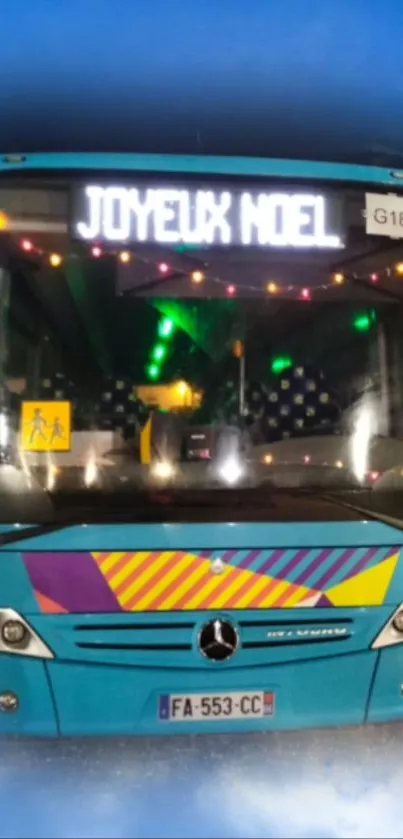 Festively decorated blue bus with holiday lights and 'Joyeux Noel' sign.