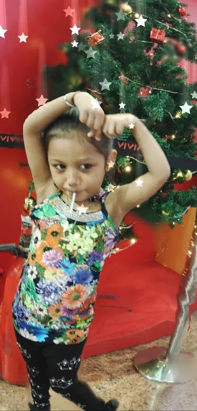 Child in front of a festive Christmas tree wearing colorful attire.