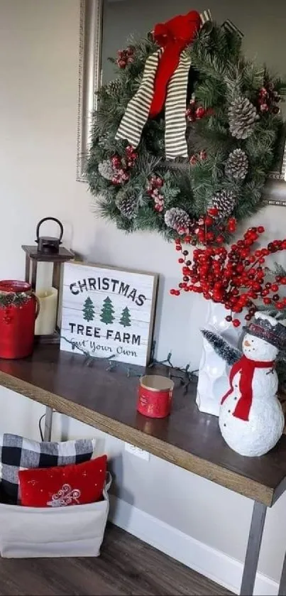 Festive holiday decor with wreath and snowman on console table.