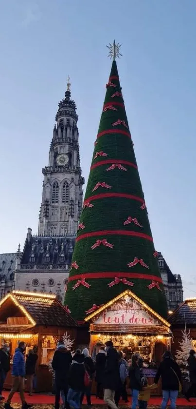 Christmas market scene with large tree and lights.