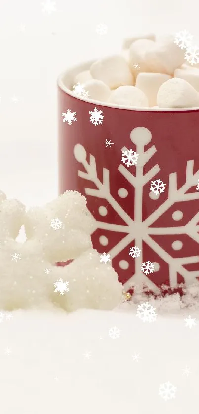 Red mug with snowflake design and candy cane on snowy background.