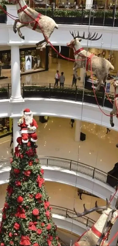 Santa and reindeer in mall Christmas display.