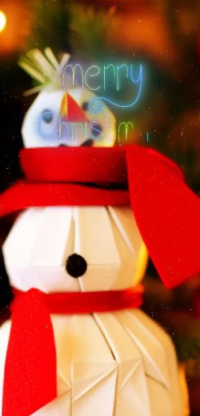 Origami snowman with red scarf amid Christmas decor.