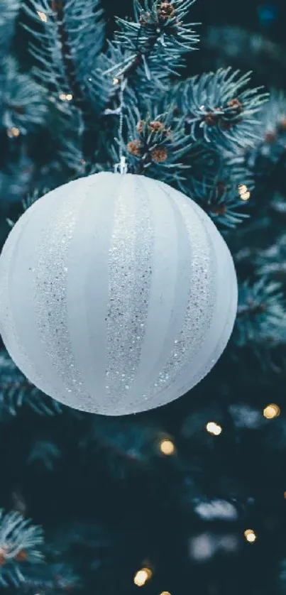 Festive Christmas ornaments on a green tree with glowing lights.