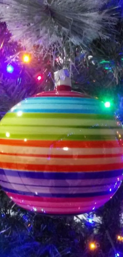 Colorful striped Christmas ornament on a tree with festive lights.