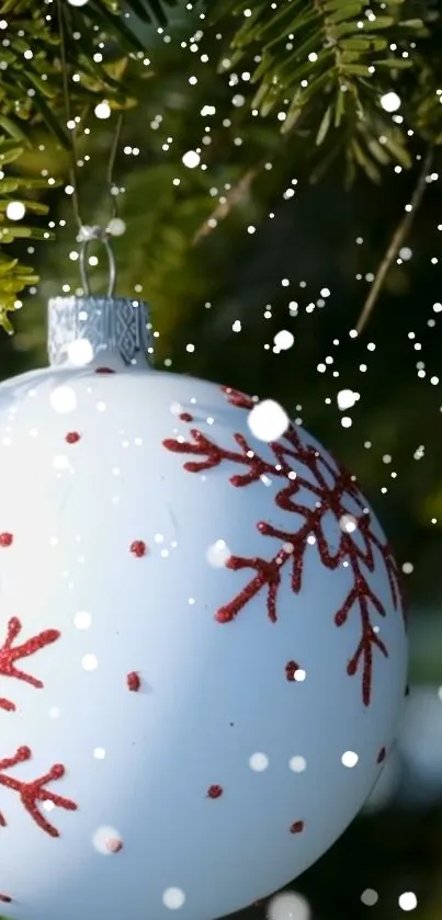 Festive Christmas ornament on pine tree with snowflakes.