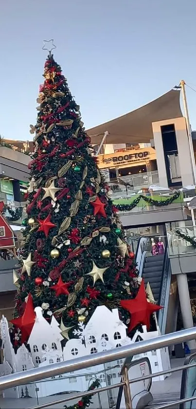 A towering Christmas tree decorated in an outdoor shopping area.