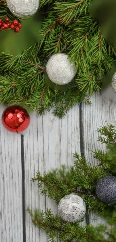 Festive pine branches with ornaments on rustic wood background.