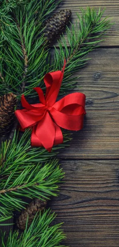 Festive pine branches with a red ribbon on wood.