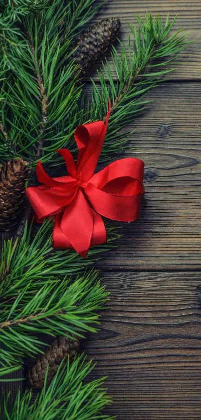 Festive wallpaper with pine branches and red bow on rustic wood.