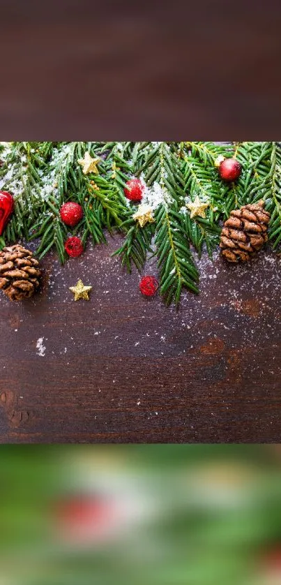 Festive mobile wallpaper with pine cones, greenery, and red ornaments on wood.