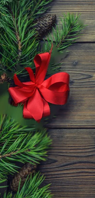 Festive mobile wallpaper with red ribbon and pine on wood.