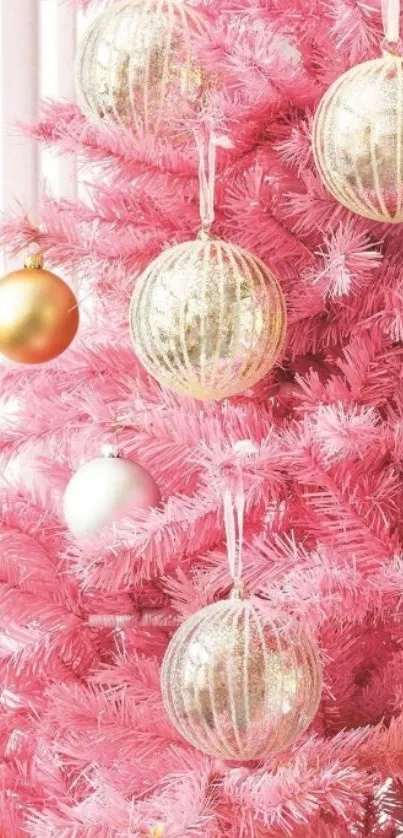 Pink Christmas tree with gold ornaments.