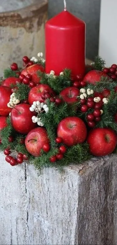 Red candle and apple arrangement on wooden block.