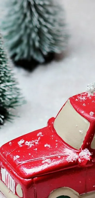 Red car in snow with festive trees.