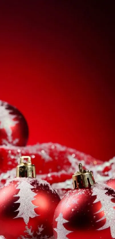 Red Christmas ornaments with snow on a dark background.