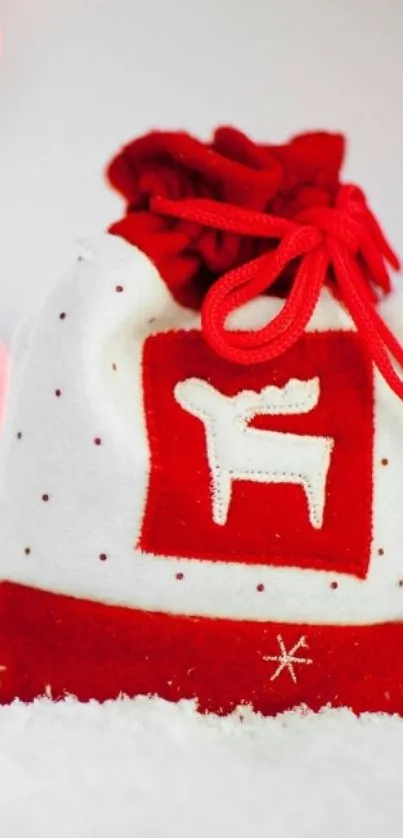 Vibrant red holiday bag with festive reindeer design on snow backdrop.