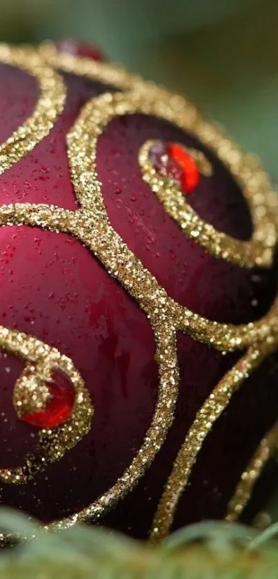 Red ornament with golden glitter on a festive wallpaper.