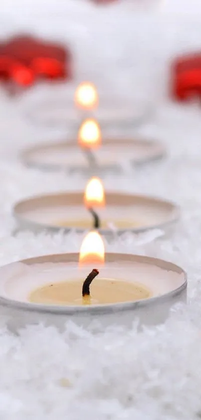 Red ornaments and candles on a snowy background for mobile wallpaper.