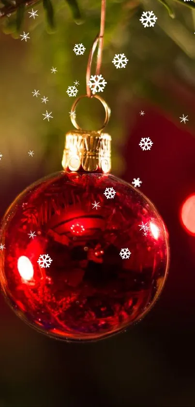 Red Christmas ornament hanging on a tree branch with blurred golden lights.