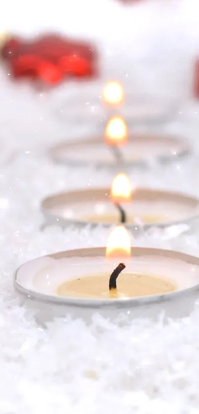 Red ornaments and candles on snow background.