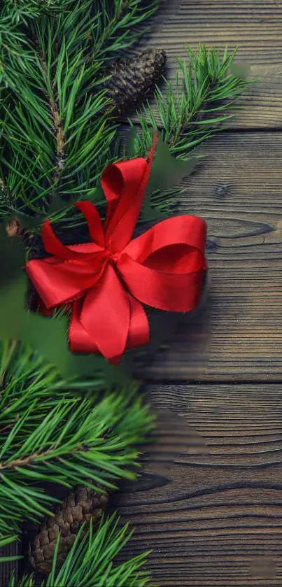 Festive mobile wallpaper with red ribbon on rustic wood and pine branches.