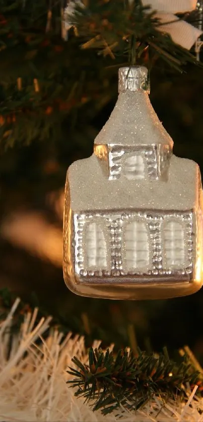 Silver ornament hanging on a Christmas tree branch, glittering among green needles.