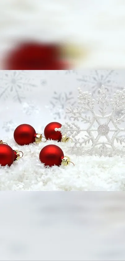 Snowflake and red ornaments on snowy background.