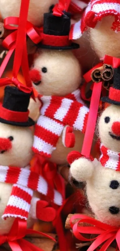 Close-up of festive snowmen with red and white scarves on a mobile wallpaper.