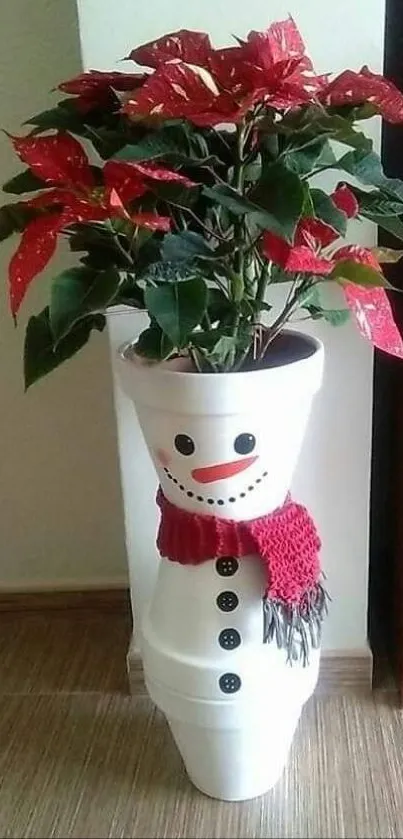 A snowman plant pot with red poinsettias for a festive holiday look.