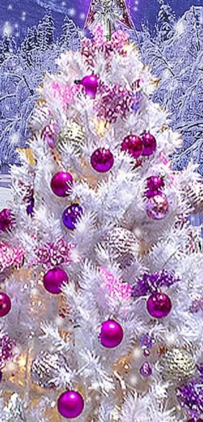 White Christmas tree with pink and silver ornaments in snowy setting.