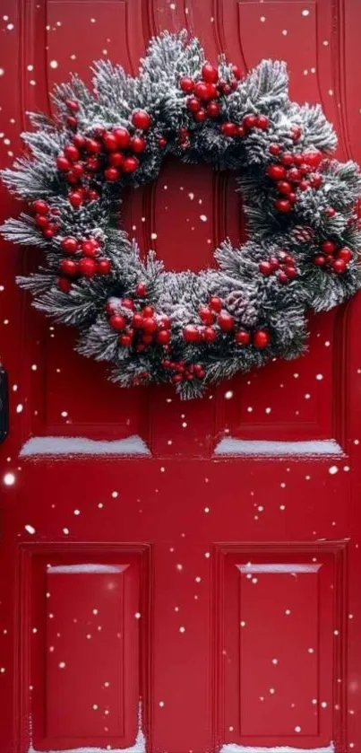 A festive wreath with berries on a red door, dusted with snow.