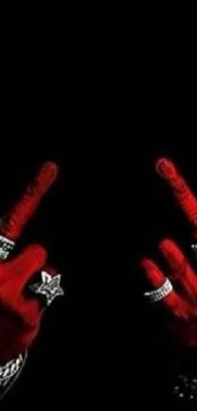 Red hands with jewelry against black background.