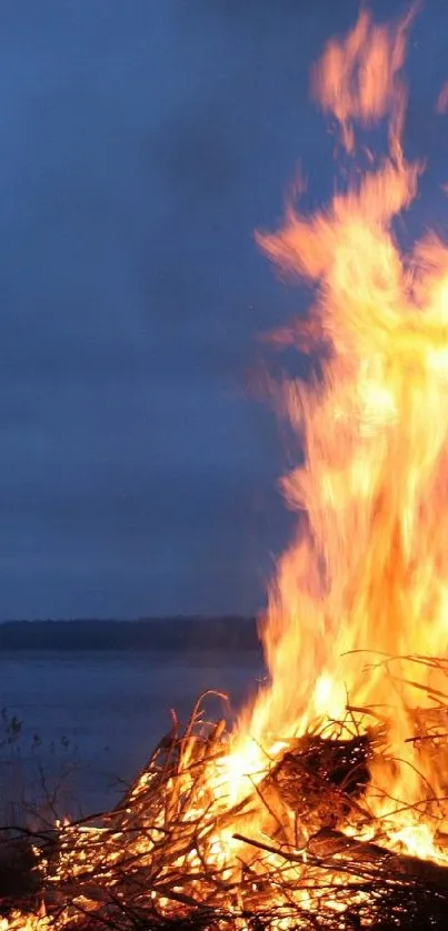 Bonfire illuminating the night by a tranquil lake scene.