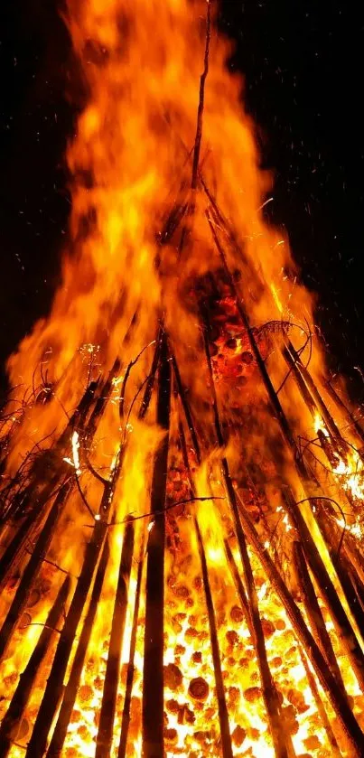 Vibrant bonfire with vivid orange flames against a dark night sky.