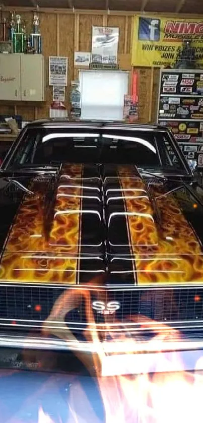 Classic black car with orange flames in a garage.