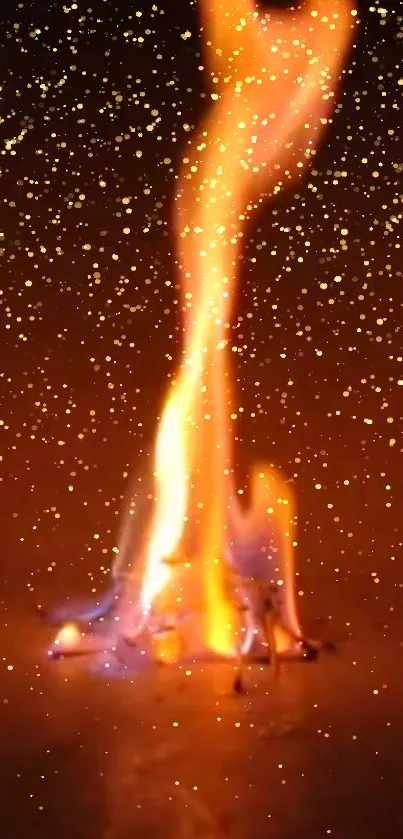 Fiery flame with glowing sparkles on dark background.