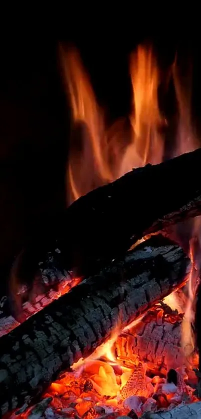 Glowing fire logs with intense flame in a dark background wallpaper.